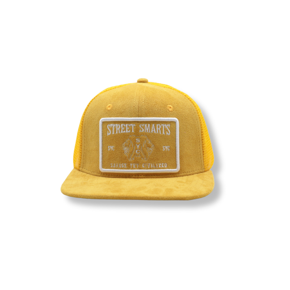 Mustard suede trucker hat with structured crown, curved brim, and adjustable strap featuring "Street Smarts" patch design